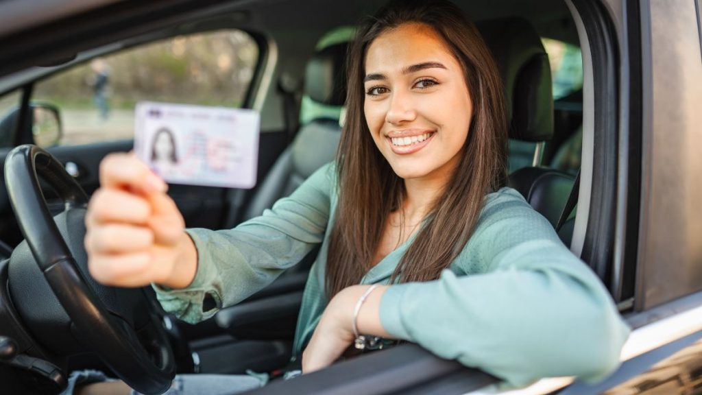a woman in a car holding a license