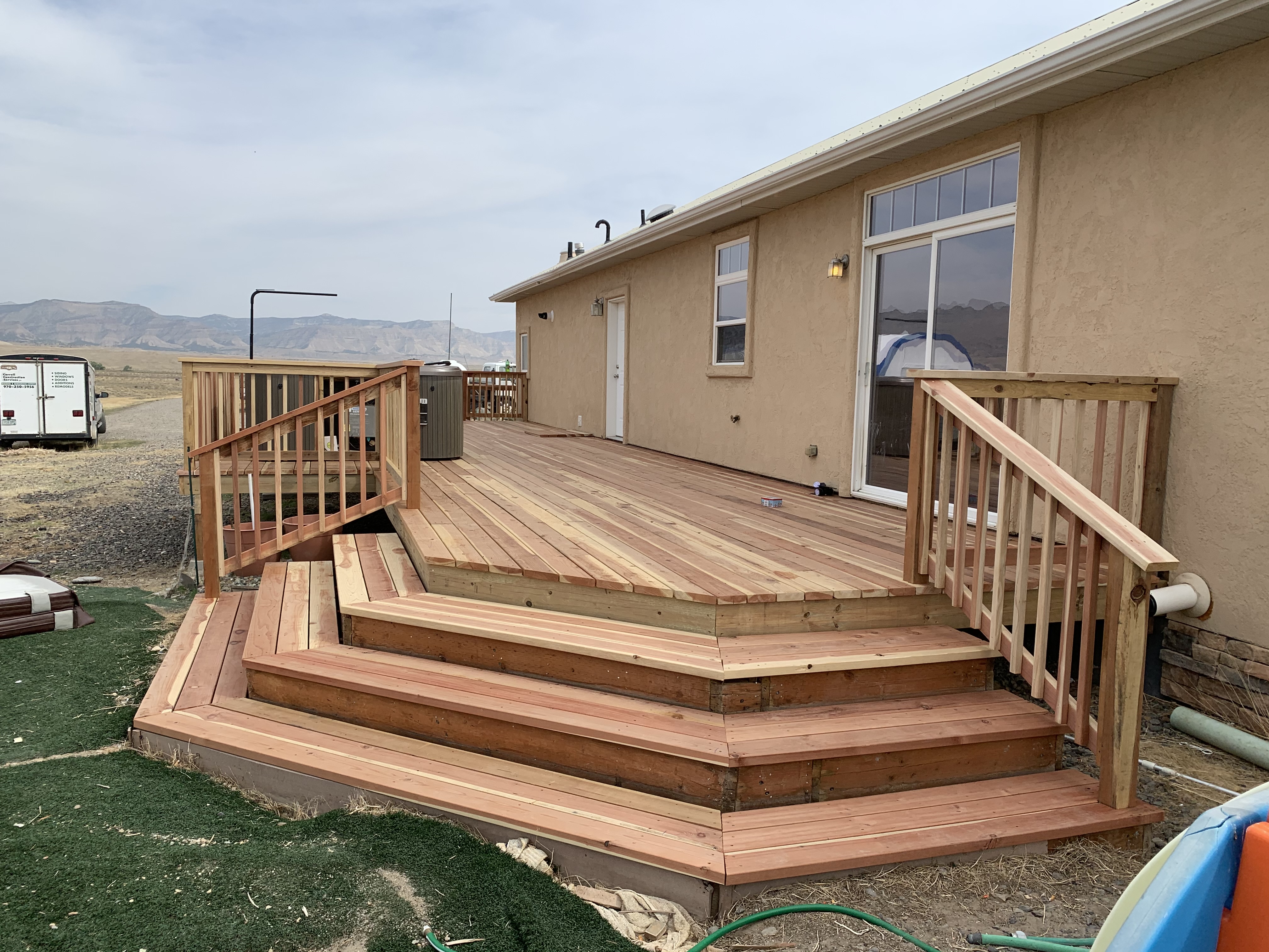a wooden deck with stairs outside of a house