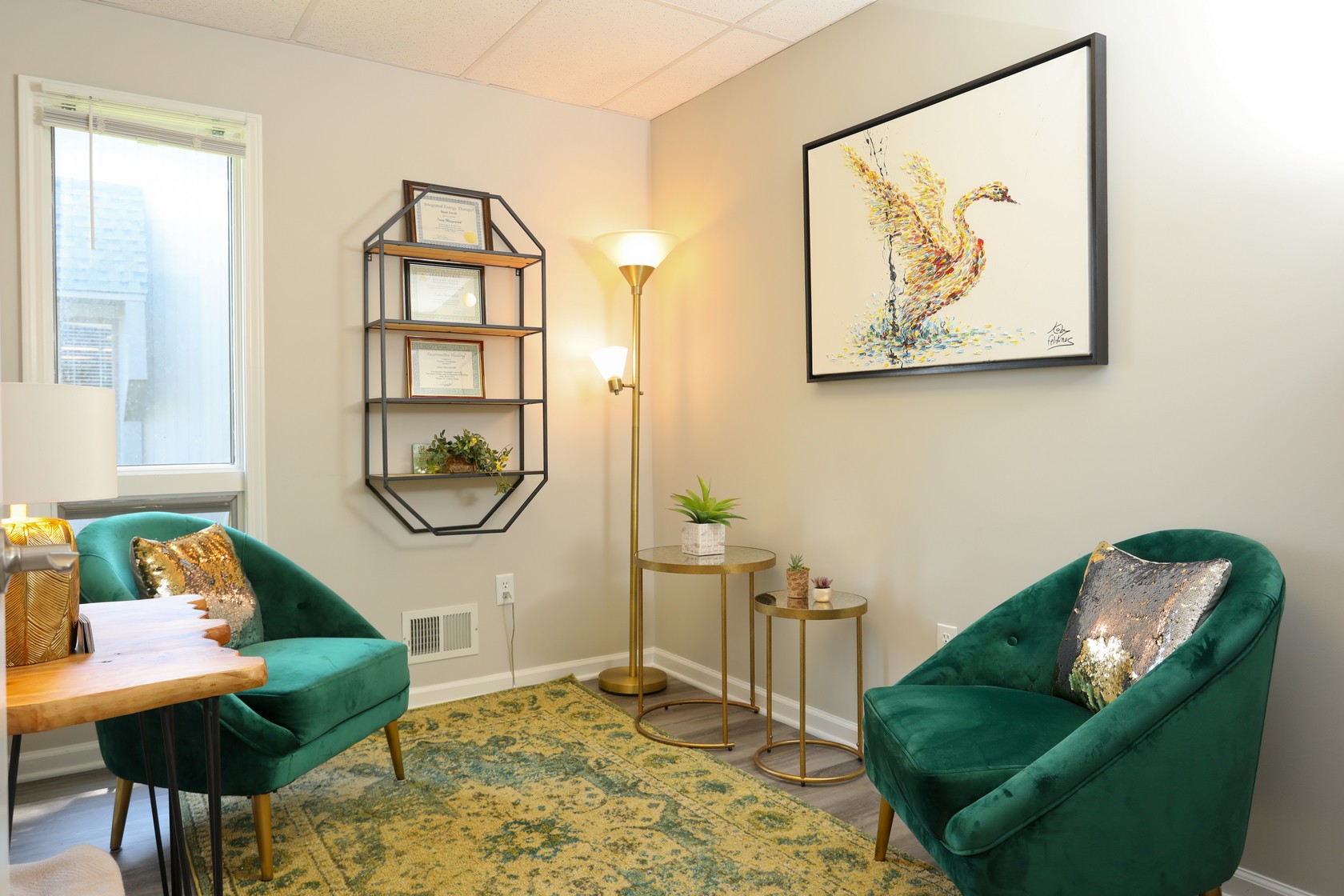 a room with green chairs and a painting on the wall