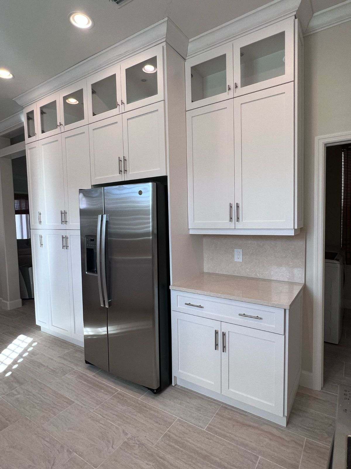 a kitchen with white cabinets and a refrigerator