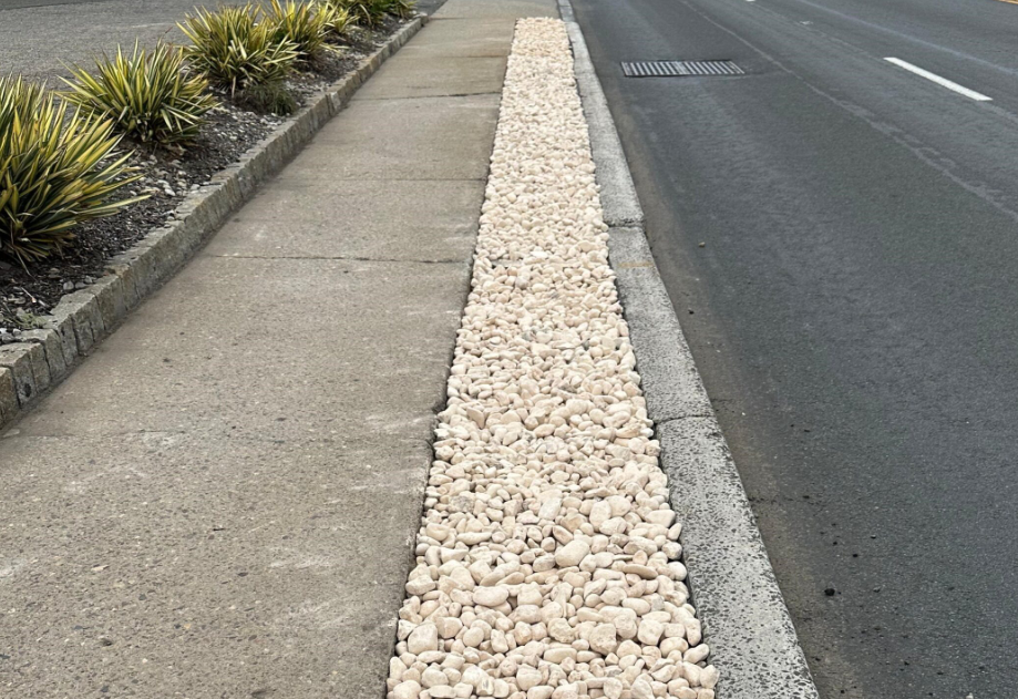 a road with a row of white rocks