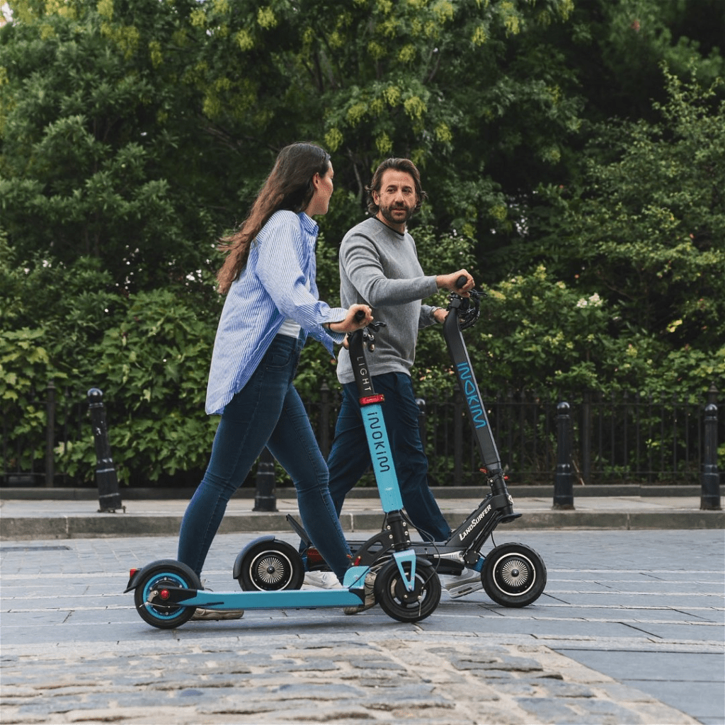 a man and woman riding scooters