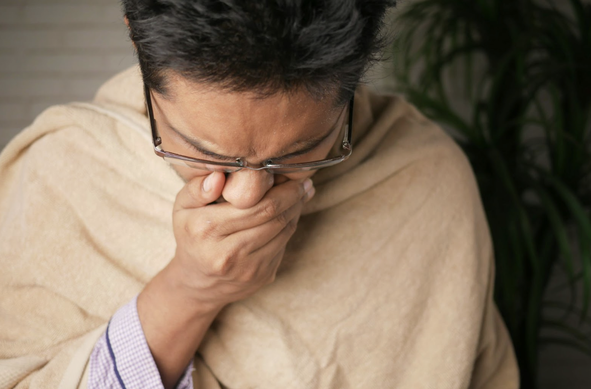 a person with glasses and a blanket covering their face