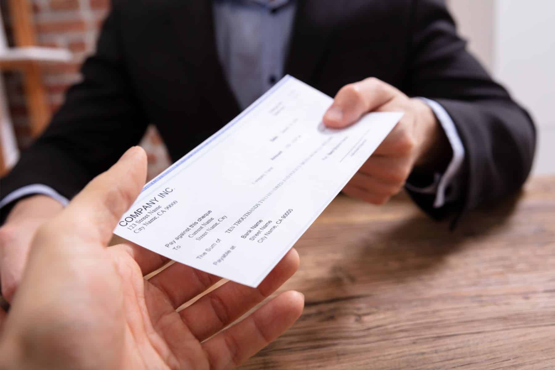 a person handing over a check