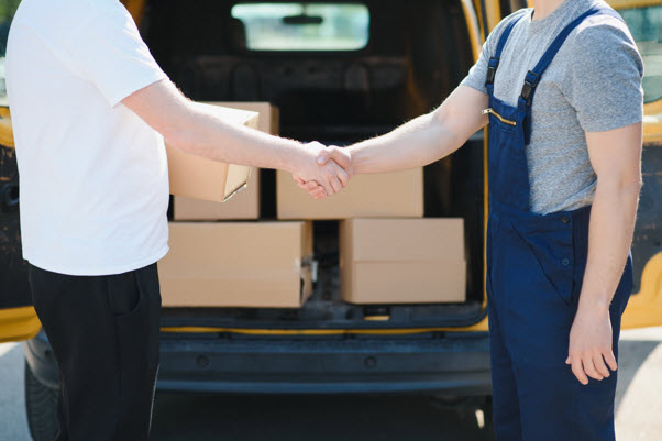 a man shaking hands with another man in a van