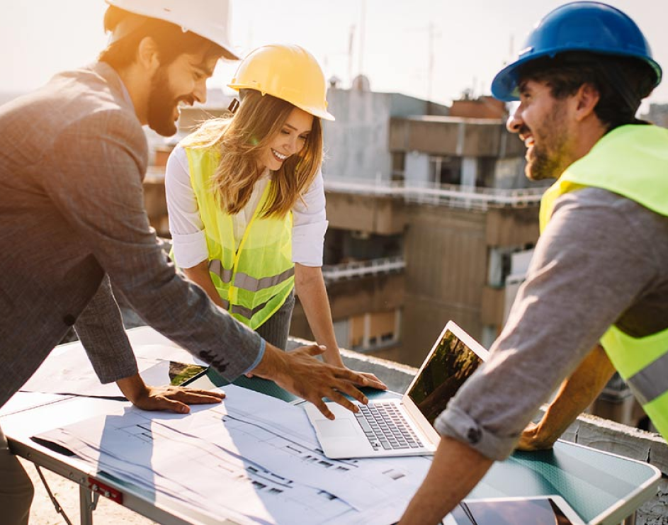 a group of people wearing hard hats and a laptop