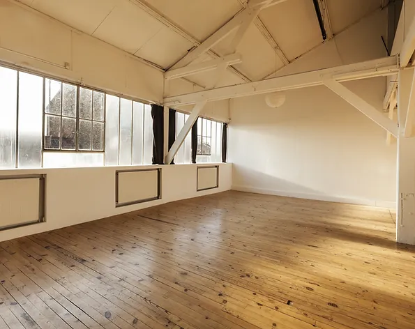 a room with wooden floor and windows