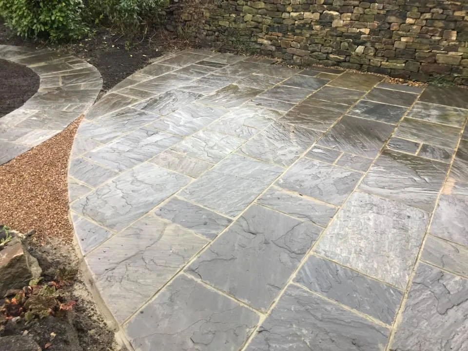 a stone patio with a stone wall