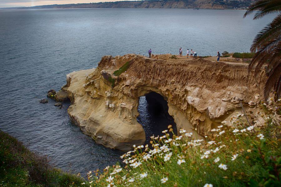 a cliff with a hole in the water