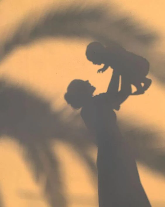 a shadow of a woman holding a baby