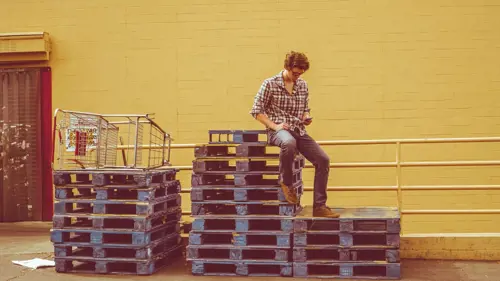 a man sitting on a stack of crates