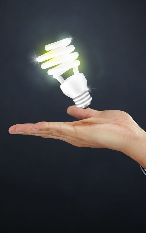 a hand holding a light bulb