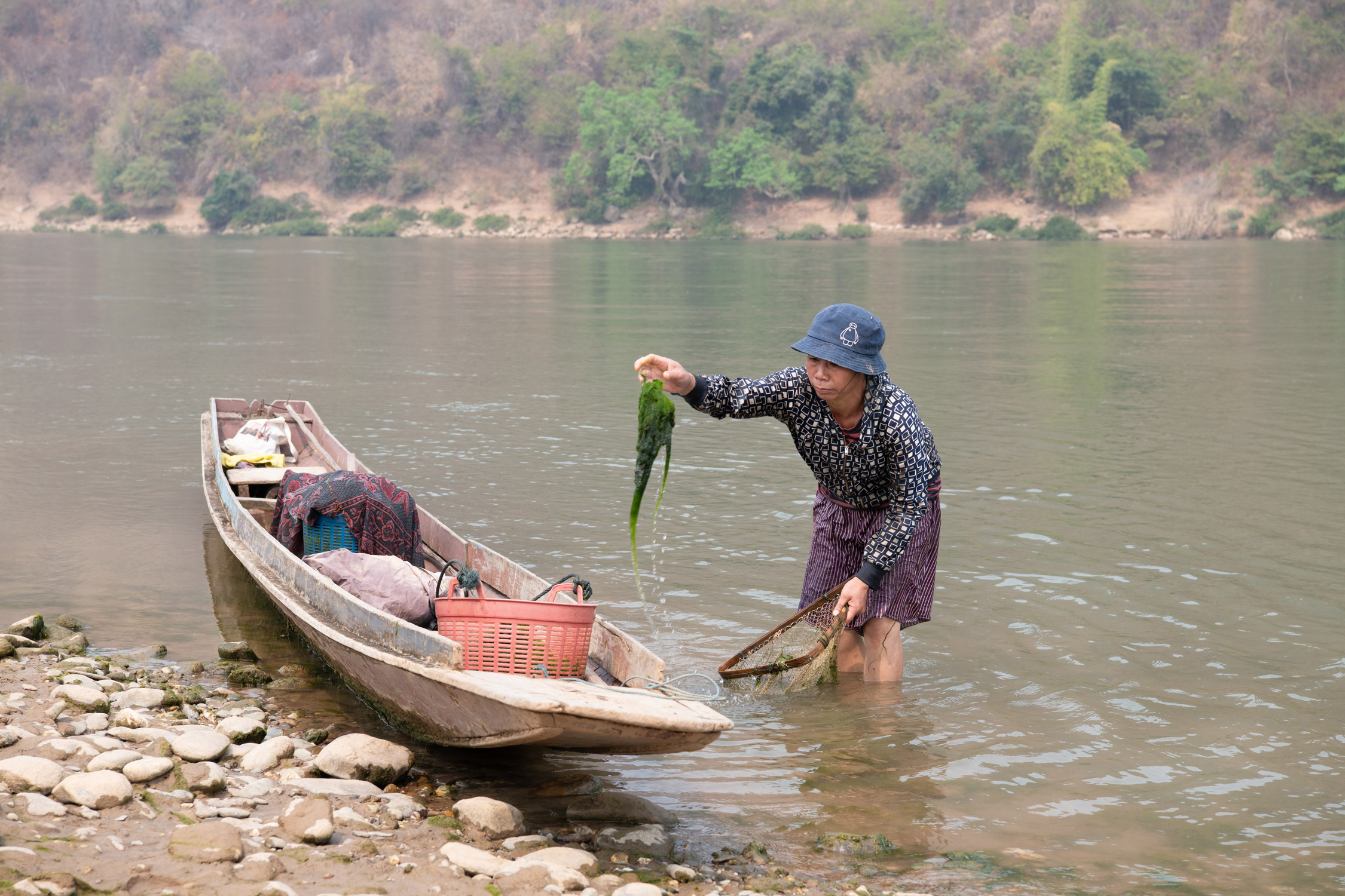 a woman holding a fish in a boat