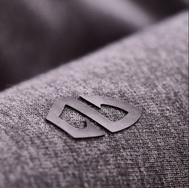 a black logo on a grey fabric