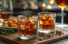 two glasses of alcohol on a wooden tray