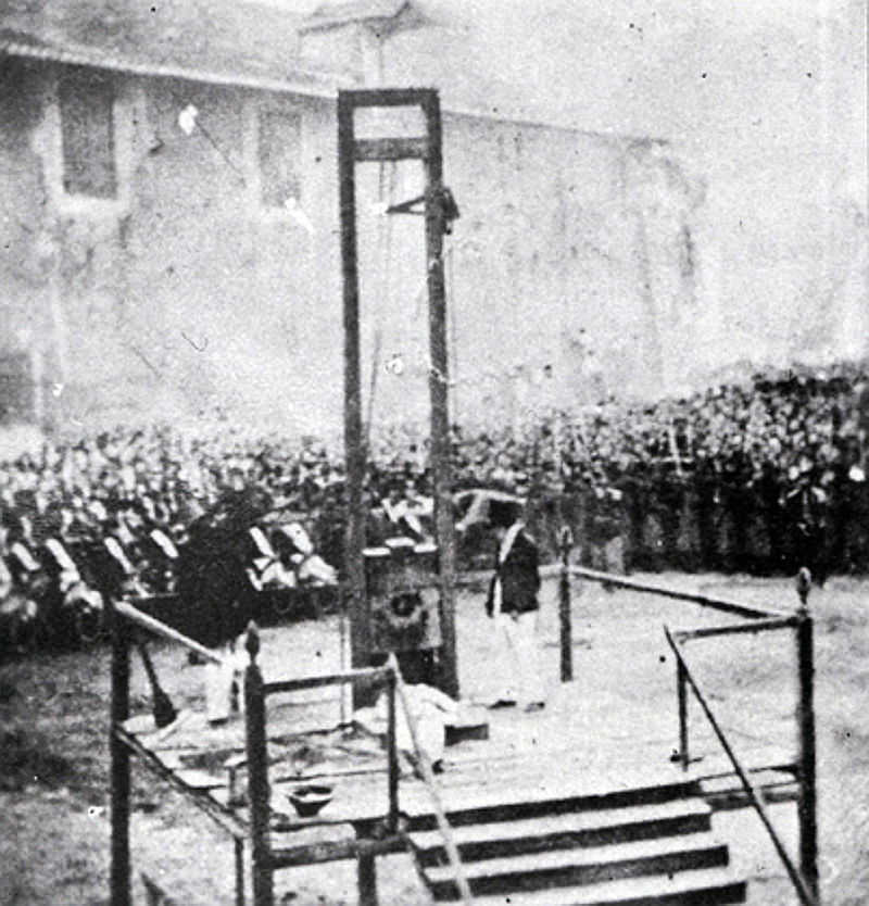 a black and white photo of a man standing in front of a group of people