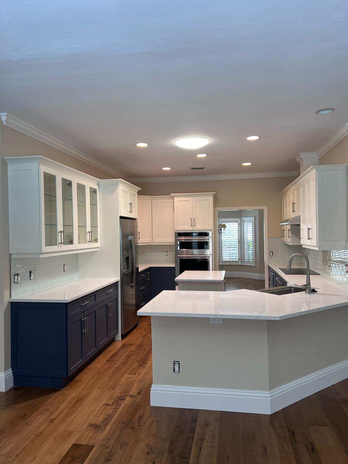 a kitchen with white cabinets and a blue island