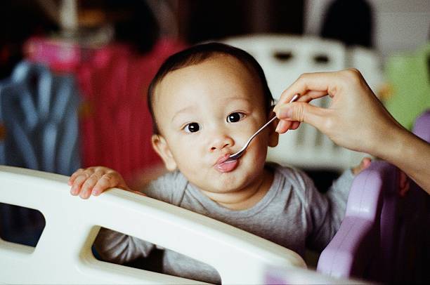 a baby being fed by a spoon