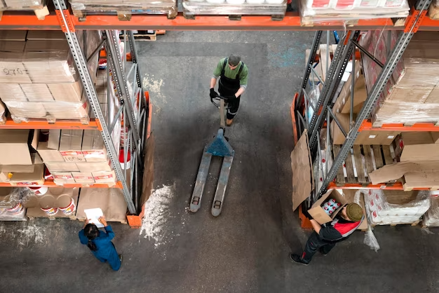 a man in a warehouse with a pallet jack