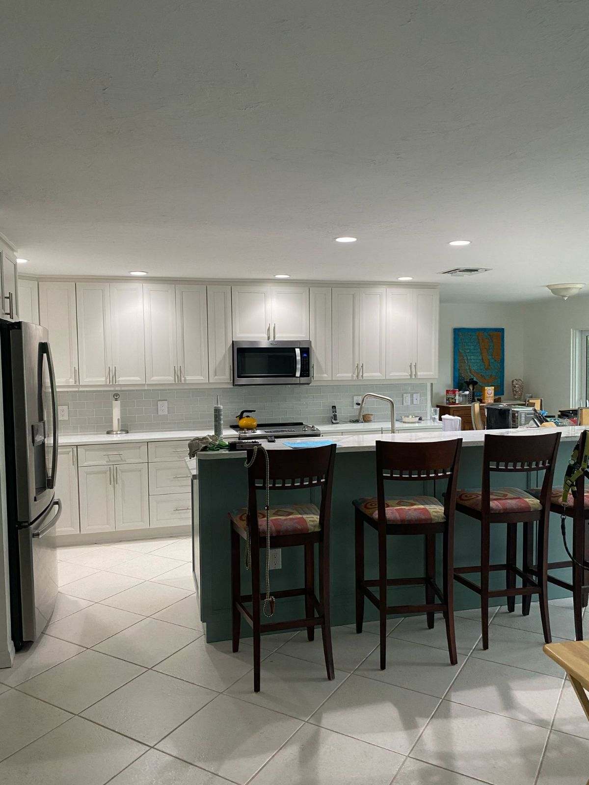 a kitchen with white cabinets and a bar stools