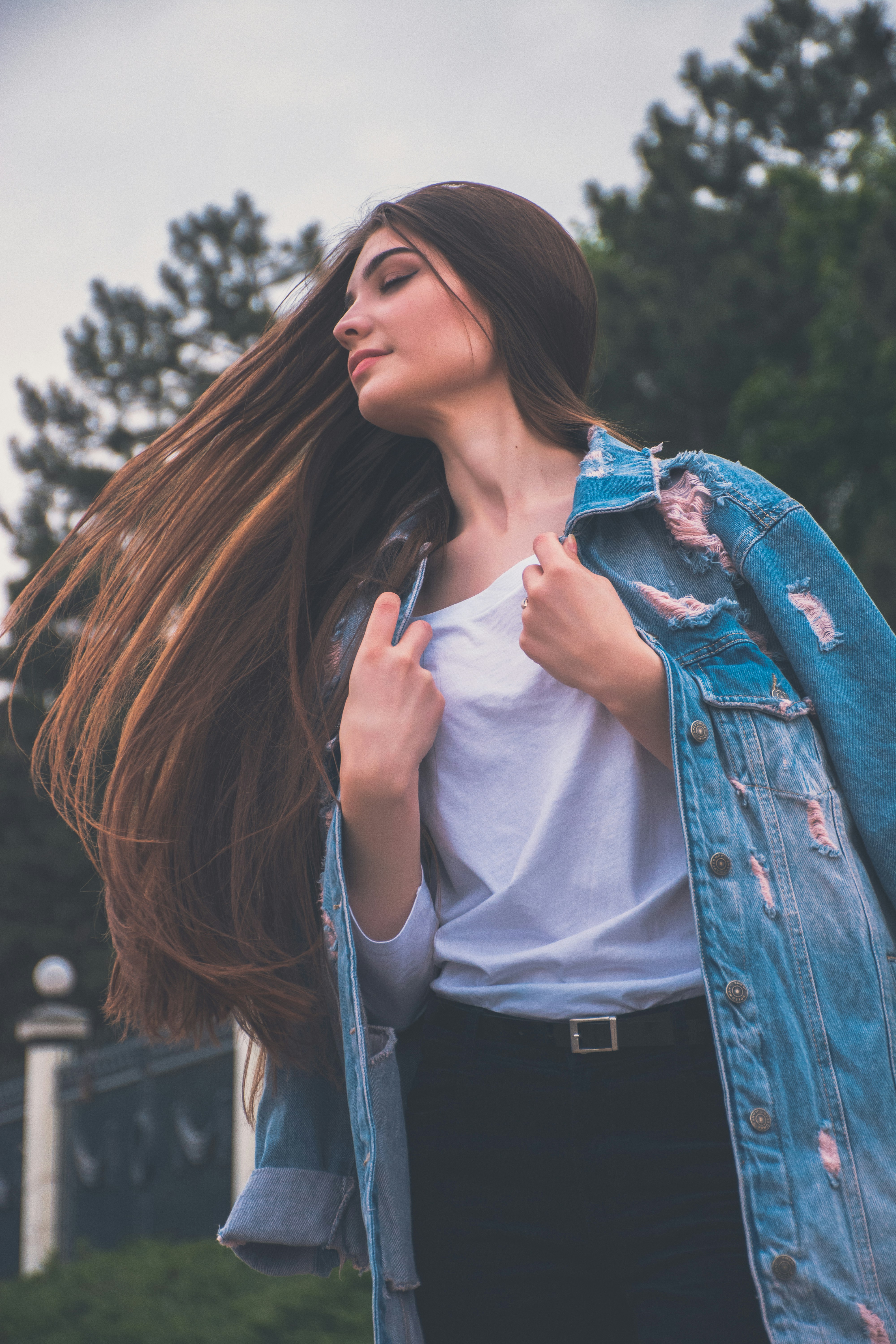 a woman with long hair wearing a denim jacket