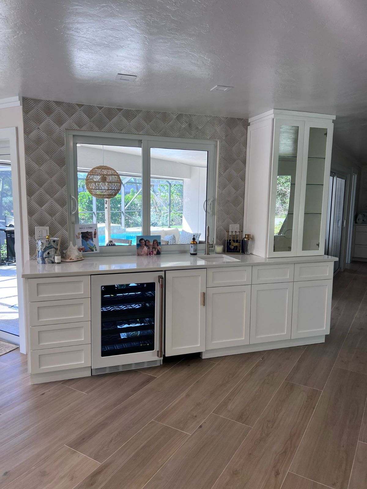 a kitchen with white cabinets and a wine cooler
