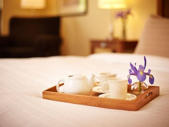 a tray of tea and coffee on a bed