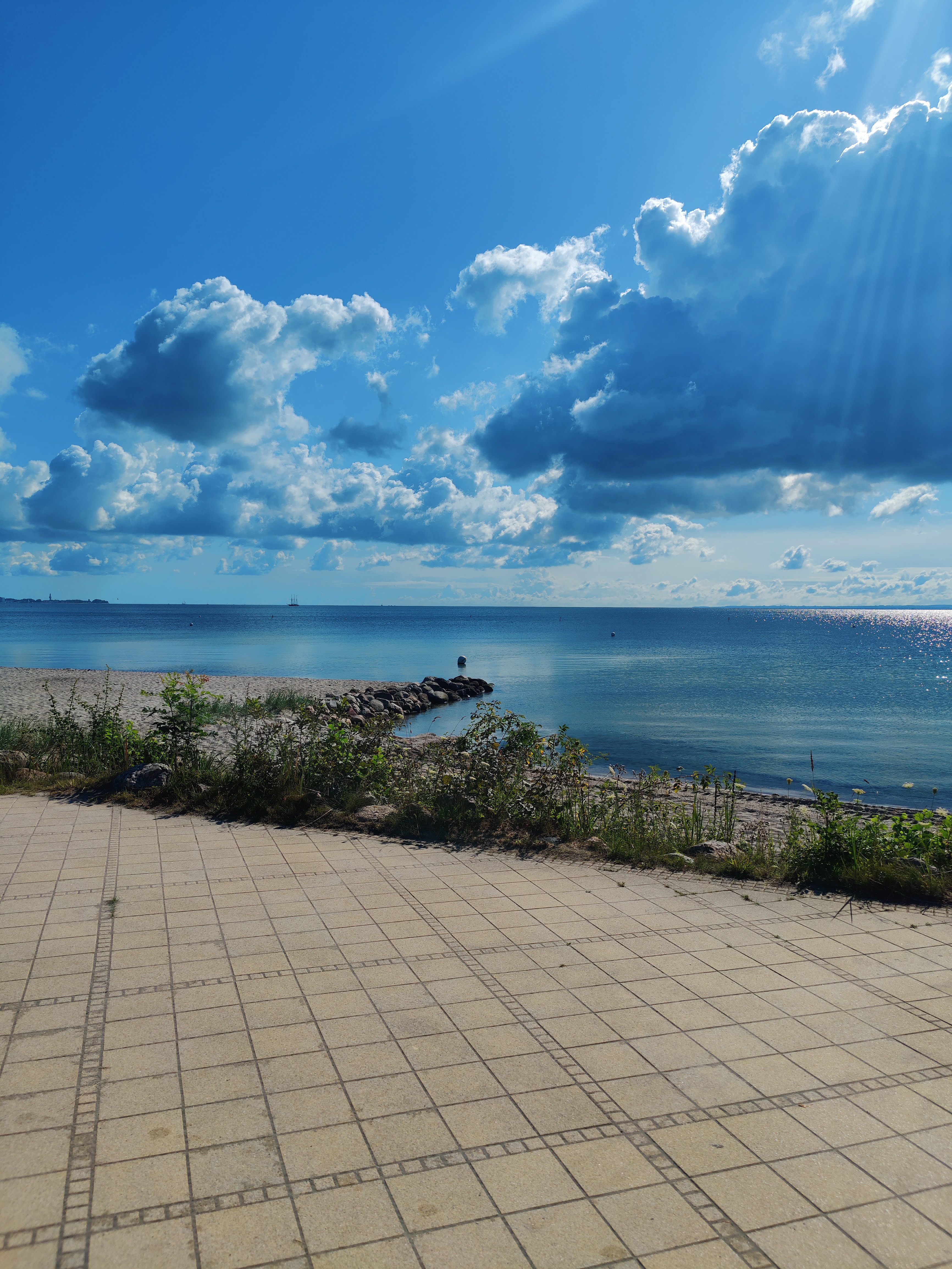 a beach with a body of water and a cloudy sky