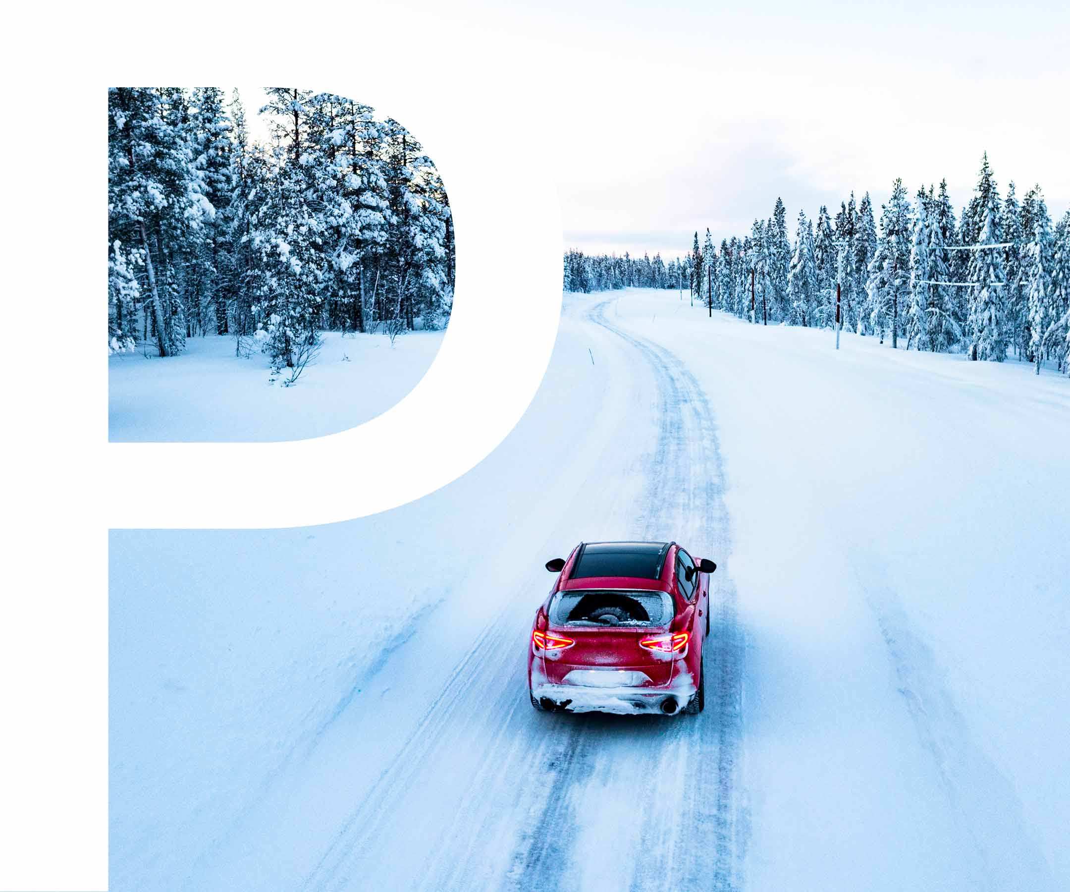 a red car driving on a snowy road