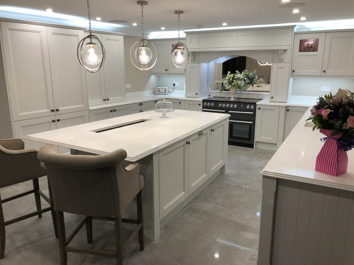 a kitchen with white cabinets and a large island