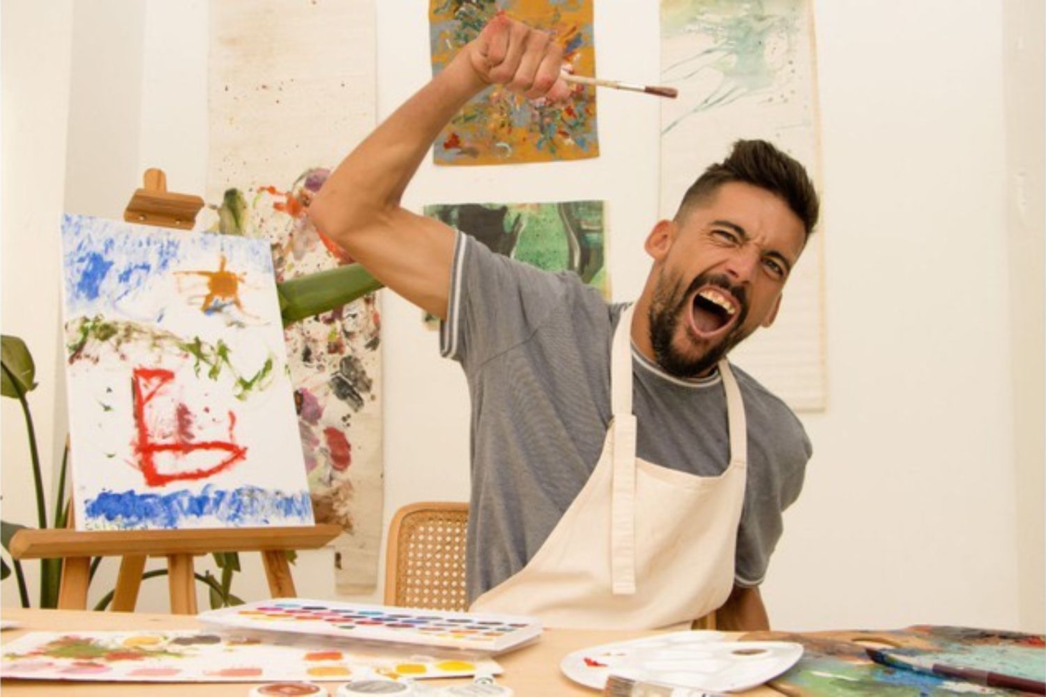 a man in an apron holding a paint brush