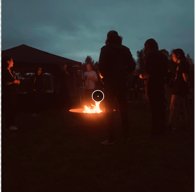 a group of people around a fire pit