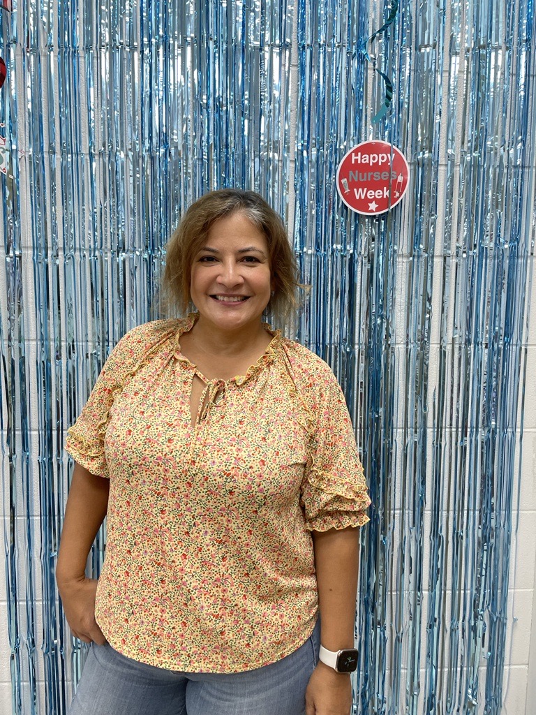 a woman standing in front of a blue curtain