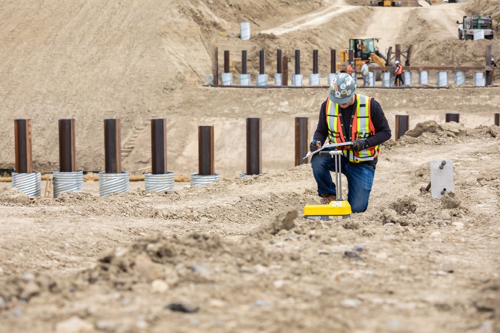 a man in a safety vest and helmet working on a construction site