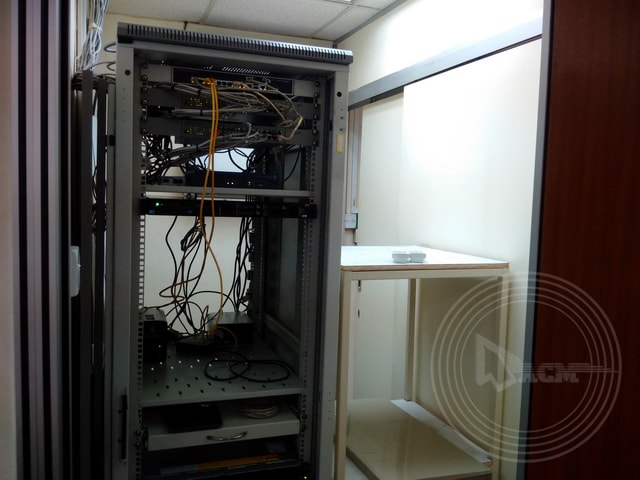 a computer server with wires and a shelf