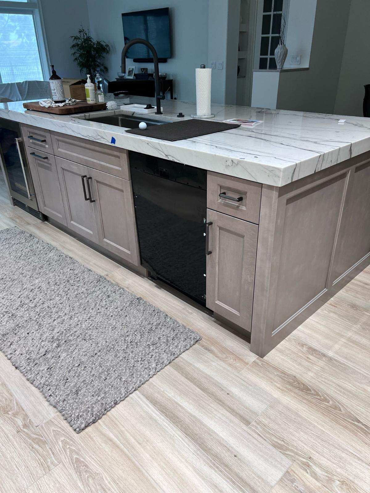 a kitchen island with a sink and a dishwasher