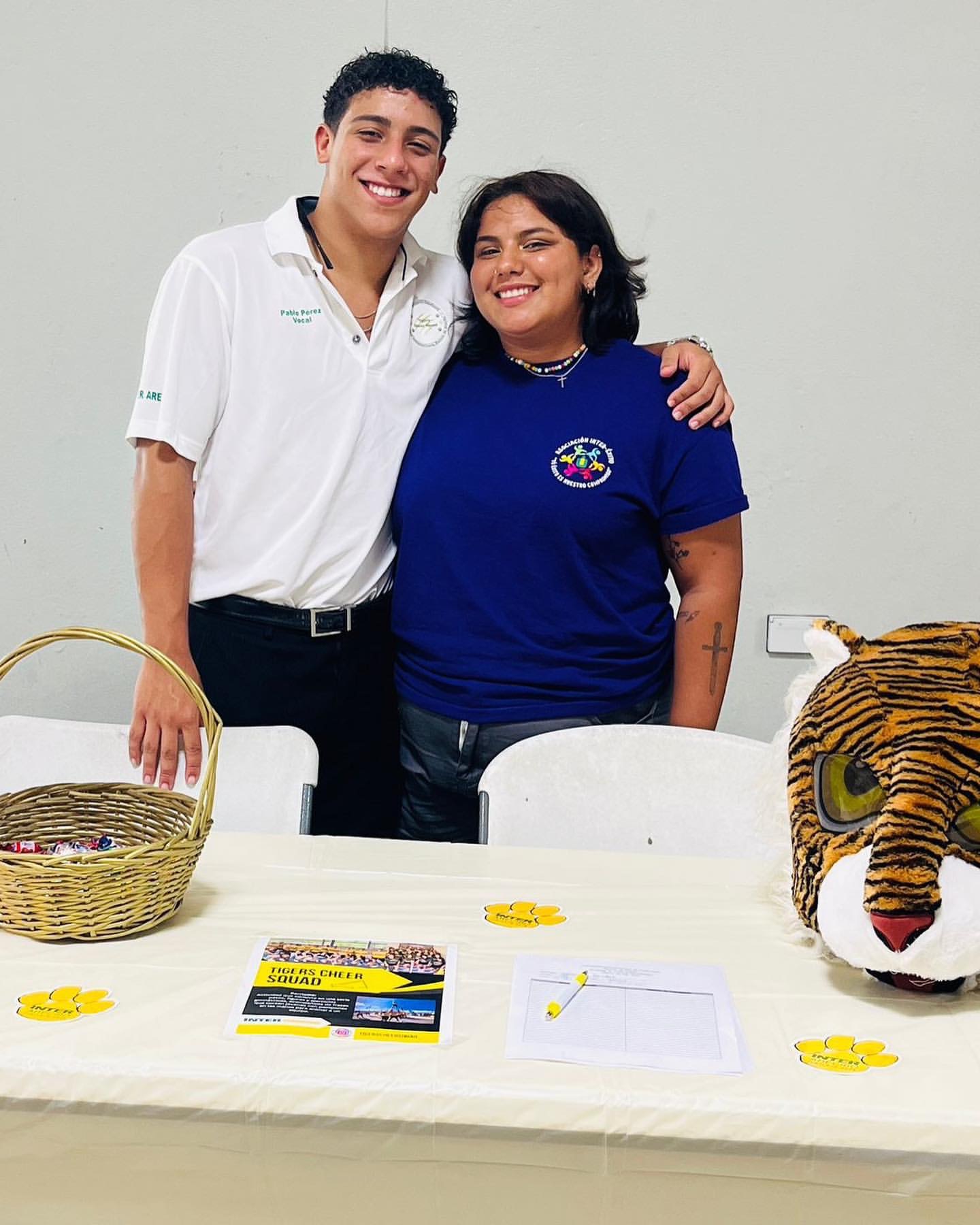 a man and woman standing next to a table with a tiger garment