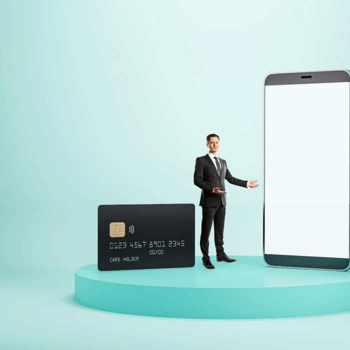 a man standing next to a large cellphone and a credit card