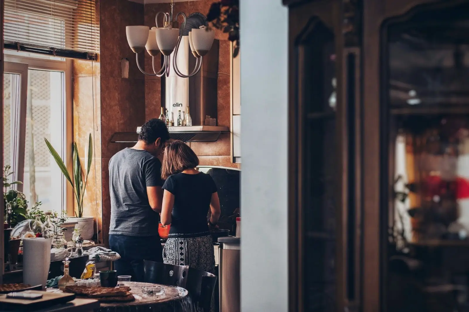 a man and woman standing in a kitchen