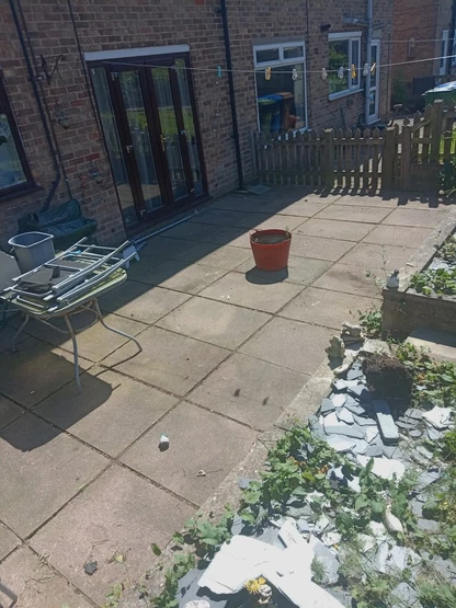 a patio with a planter and a bucket on it