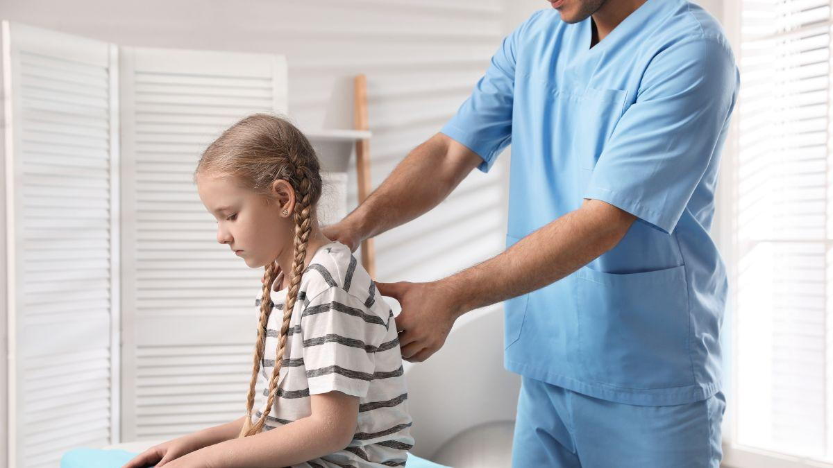 a man in blue scrubs holding a girl's back