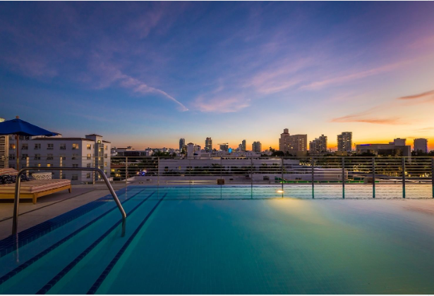 a pool with a railing and a city in the background