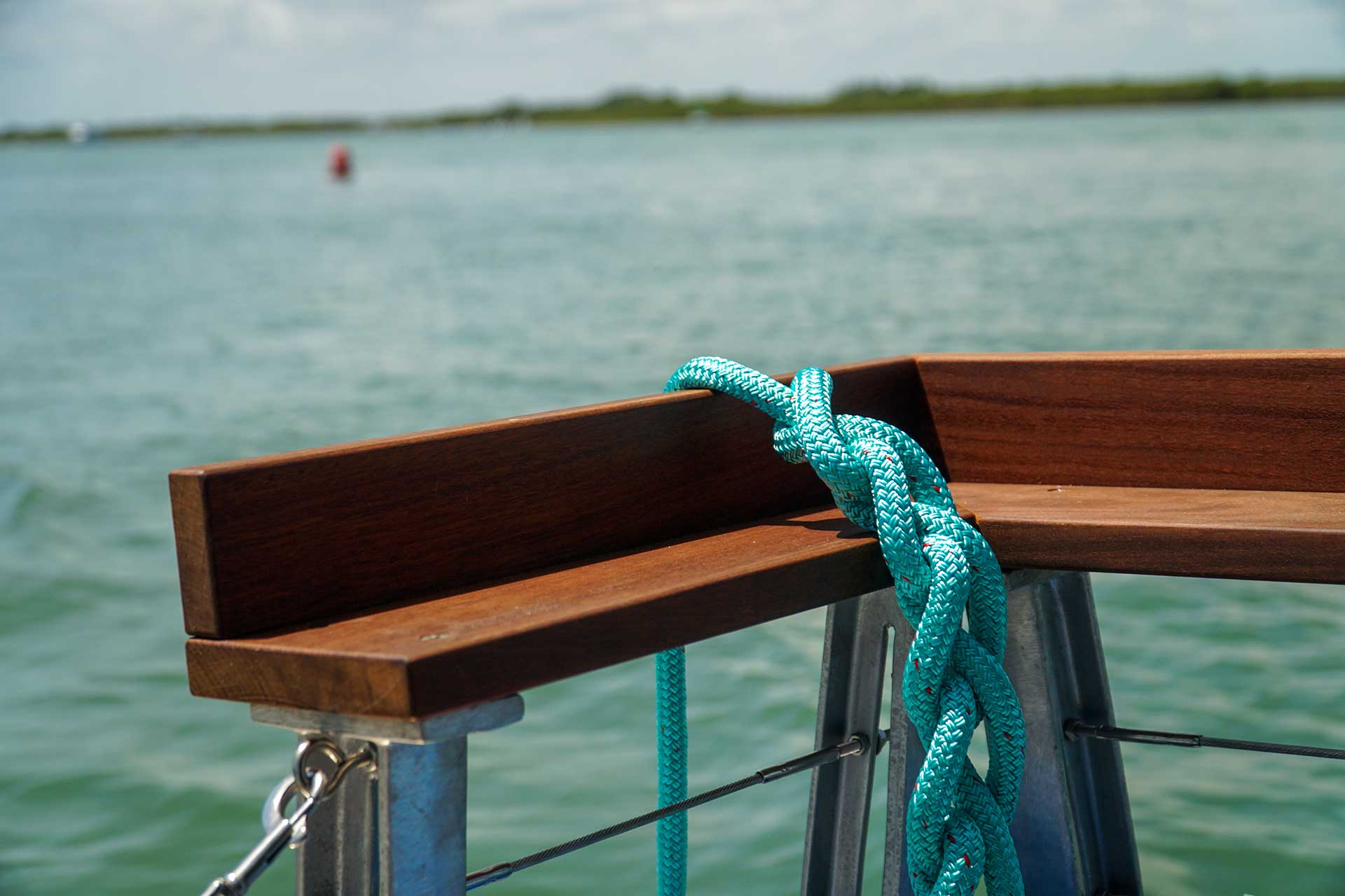 a rope tied to a wooden railing on a boat