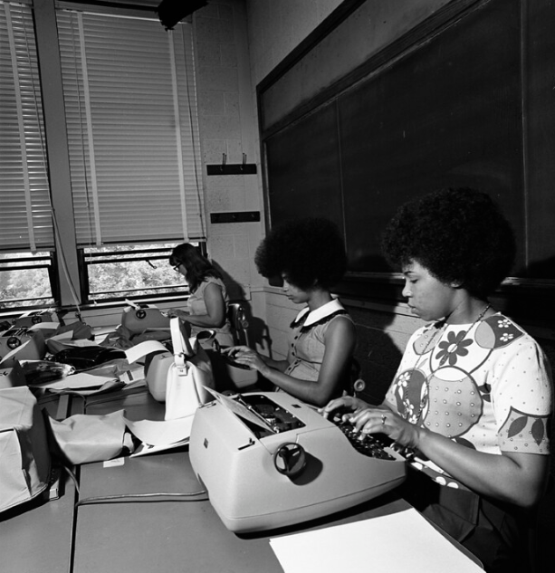 a group of women working on typewriters