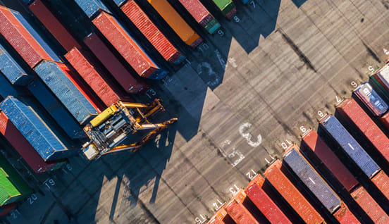 a crane in a parking lot with containers