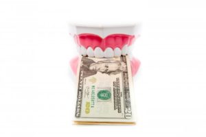 a fake teeth and money in a mouth