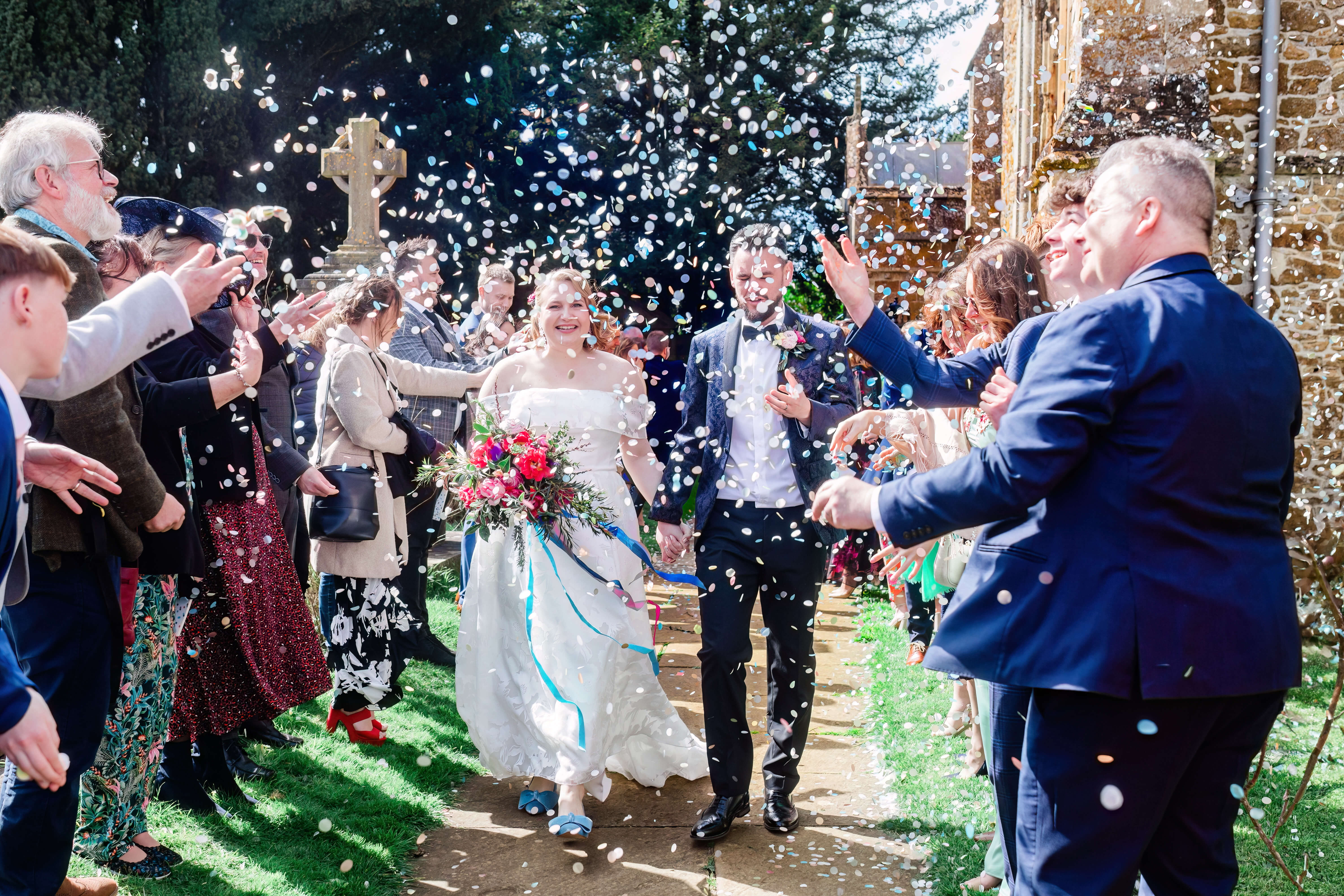 a man and woman walking down a path with confetti falling