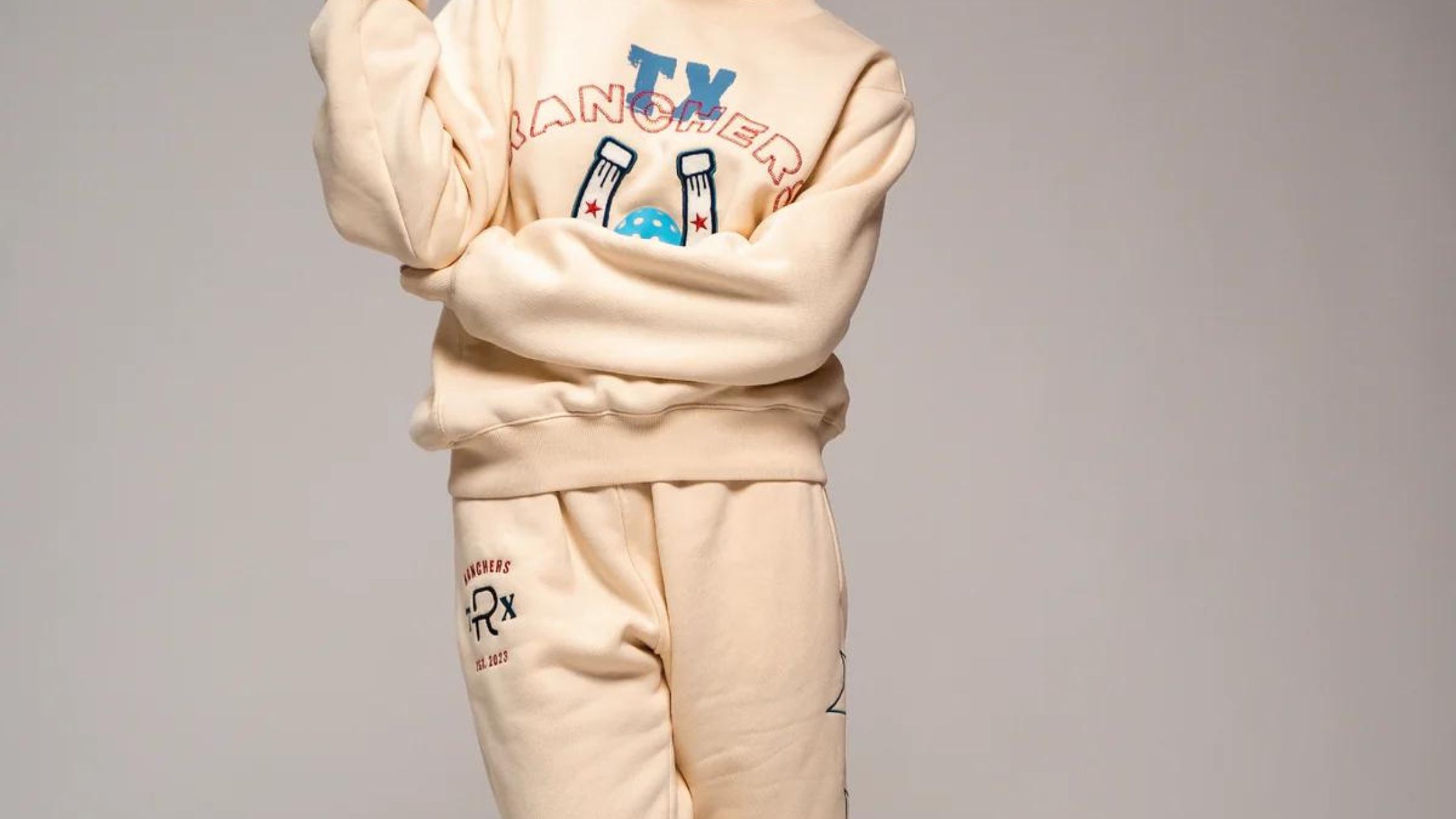 a child wearing a beige sweatshirt and pants