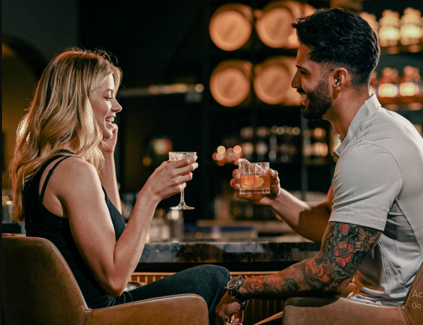 a man and woman sitting at a table with drinks