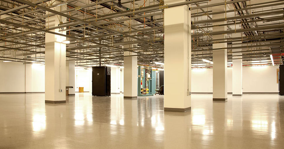 a large room with white pillars and pipes